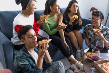 Bir grup Latin LGBT arkadaşı pizza yiyor, içiyor ve Meksika 'da evde eğleniyorlar, Latin Amerika' da Latin homoseksüel ve lgbtq toplulukları partide.