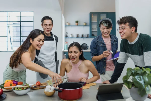 Group of latin LGBT friends cooking and preparing mexican food in kitchen at home in Mexico, Hispanic homosexual people from lgbtq community in Latin America