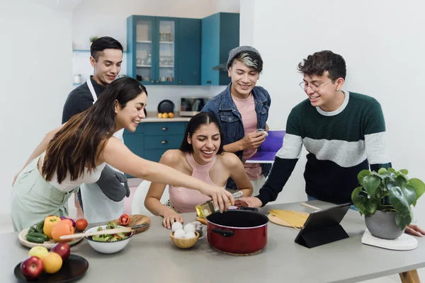 Group of latin LGBT friends cooking and preparing mexican food in kitchen at home in Mexico, Hispanic homosexual people from lgbtq community in Latin America