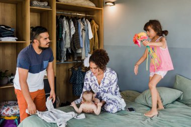 Latin kökenli Latin bir ailenin Meksika 'daki evinde bebeğinin altını değiştiren Latin bir anne.