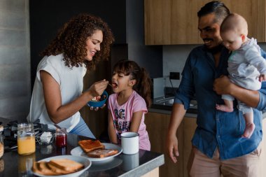 Latin Aile 'den genç anne ve baba, çocuk ve bebek sahibi. Meksika' da mutfakta kahvaltı ediyorlar. Latin Amerika 'da, İspanyol insanlar.