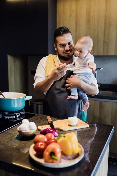 latin single father and baby son cooking at kitchen in Mexico Latin America, hispanic young family