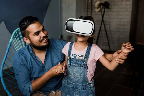 latin young father playing virtual reality game with his daughter at home in Mexico Latin America, hispanic family