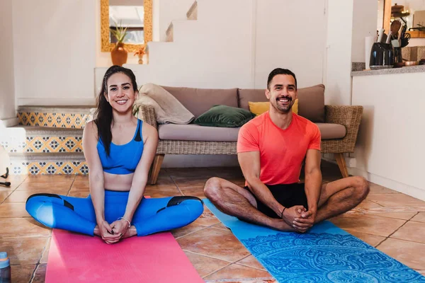 Latin young couple man and woman exercising or doing workout session at home in Mexico Latin America, hispanic people in wellness concept