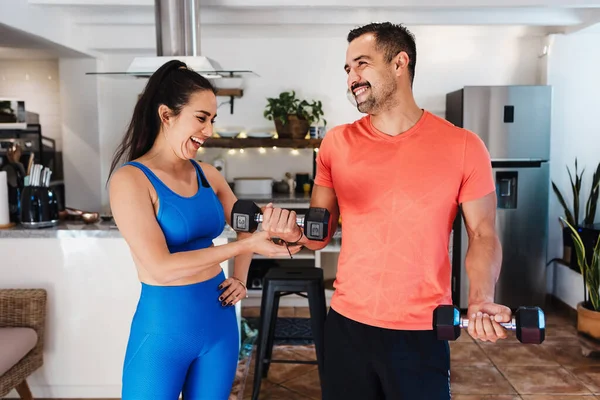 Latin young couple man and woman exercising or doing workout session at home in Mexico Latin America, hispanic people in wellness concept