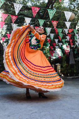 Geleneksel Meksika elbisesi giyen Latin kadın dansçı. Guadalajara Jalisco Meksika Latin Amerika 'dan. Bağımsızlık Günü' nde Latin kökenli genç insanlar. 