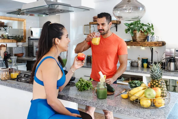 Latin fitness couple man and woman eating healthy food in kitchen at home in Mexico Latin America, hispanic people in wellness lifestyle concept