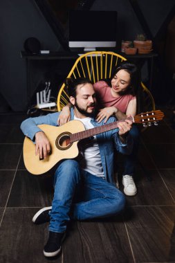 Romantik bir buluşmada gitar çalan genç Latin bir çift, Meksika 'da gece evde şarkı söyleyen kız arkadaş ve erkek arkadaş, Latin Amerikalılar.