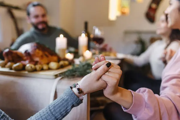 Hispanic people praying and holding hands for prayer gathering at Christmas dinner at home in Mexico. Grateful people with gratitude enjoy a thanksgiving meal with turkey in Latin America
