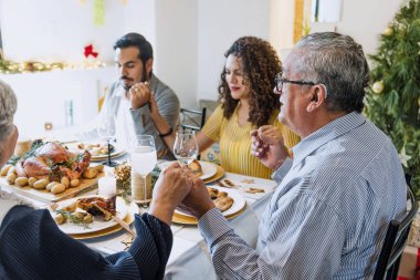 Latin Aile dua ediyor ve dua için el ele tutuşuyor. Meksika 'daki Şükran Günü yemeğinde toplanıyorlar. Minnettar insanlar Latin Amerika 'da hindi yemeğinin tadını çıkarıyorlar.