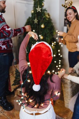 Latin arkadaşlar Meksika 'da Noel ağacına Noel ışıkları koyuyorlar.