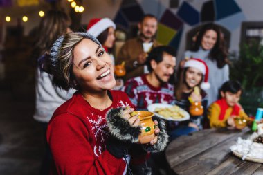 Latin kökenli genç kadın portresi Meksika 'da Noel arifesi kutlaması için geleneksel Meksika posadasında.