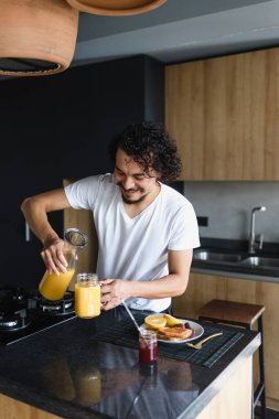 Latin Amerika 'da mutfakta meyve ve meyve suyu hazırlayan Latin Amerikalı genç bir adam.