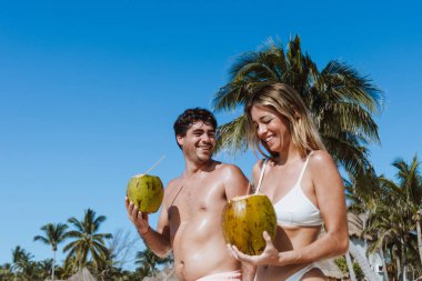 İspanyol genç çift hindistan cevizi tutuyor ve tatillerde ya da Meksika Latin Amerika 'da tatillerde Karayip sahillerinde eğleniyorlar.