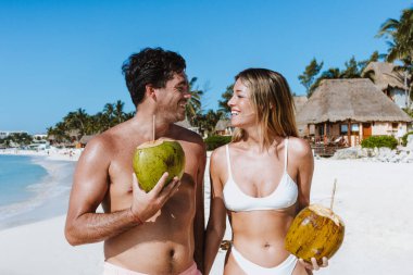 İspanyol genç çift hindistan cevizi tutuyor ve tatillerde ya da Meksika Latin Amerika 'da tatillerde Karayip sahillerinde eğleniyorlar.