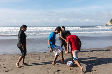 Acapulco Meksika 'daki Pasifik Okyanusu' nda futbol ya da futbol oynayan mutlu Latin arkadaşlar. Latin Amerikalılar eğleniyor.