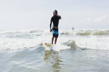 Latin sörfçü adam Meksika 'da tropikal dalgalarda sörf yapıyor Latin Amerikalılar yaz sporlarında sörf yapıyor.