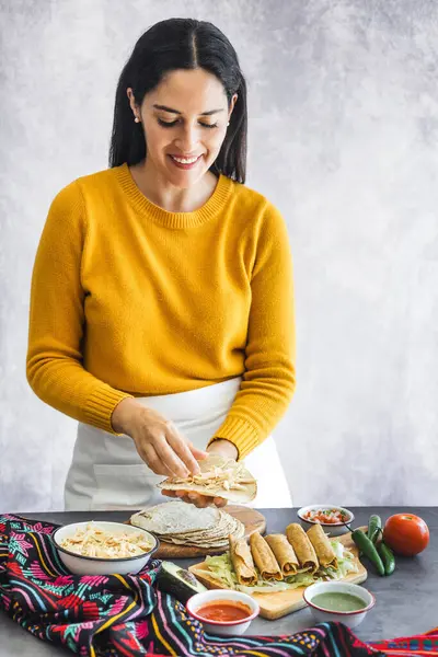 stock image Mexican woman cooking tacos dorados called flautas with chicken, traditional fried food in Mexico Latin America