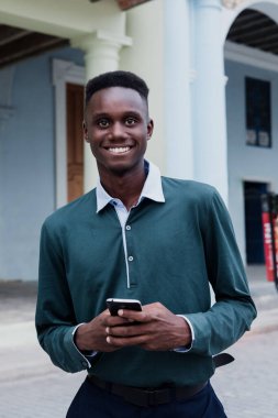 Genç Afrikalı Amerikalı cep telefonuyla konuşuyor, Latin Amerika 'da genç Karayipli siyahlar mesaj yolluyor.