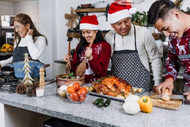 Meksika 'da Noel yemeği için evde hindi eti pişiren Meksikalı aile Latin Amerika' da, İspanyol asıllı genç kızları, oğulları, anneleri ve babaları tatilde.