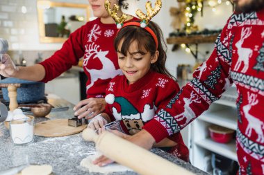 Meksikalı anne, baba ve kız tatillerde Meksika 'da evde Noel kurabiyesi pişiriyorlar.