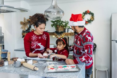 Meksikalı anne, baba ve kız tatillerde Meksika 'da evde Noel kurabiyesi pişiriyorlar.