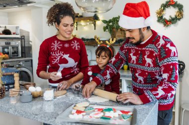Meksikalı anne, baba ve kız tatillerde Meksika 'da evde Noel kurabiyesi pişiriyorlar.
