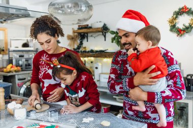 Meksikalı anne, baba ve kız tatillerde Meksika 'da evde Noel kurabiyesi pişiriyorlar.