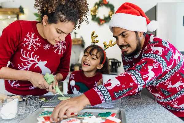 Meksikalı anne, baba ve kız tatillerde Meksika 'da evde Noel kurabiyesi pişiriyorlar.
