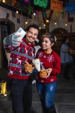 Meksikalı genç çift ya da arkadaşlar Meksika 'da Noel arifesinde Posada' da eğleniyorlar Latin Amerika 'da, İspanyol bayramlarında