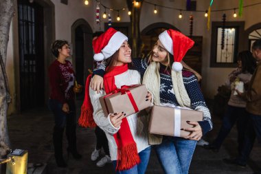 Latin kızlar ya da hediye taşıyan birkaç arkadaş ya da hediye kutusu Meksika 'da Noel arifesini kutlarken Latin Amerika' da, İspanyol asıllı insanlar ve Posadas adında gelenekler