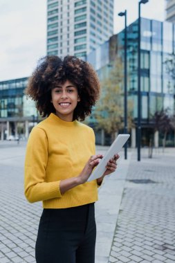 İspanya 'da dijital tablet kullanan genç Afrikalı Amerikalı iş kadını. Avrupa ve Karayipler' de gökdelen geçmişi olan insanlar.