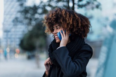 İspanya 'da konuşan ve cep telefonu kullanan genç Afrikalı Amerikalı iş kadını. Avrupa' da, mali ve Karayipler 'de gökdelen geçmişi olan insanlar.