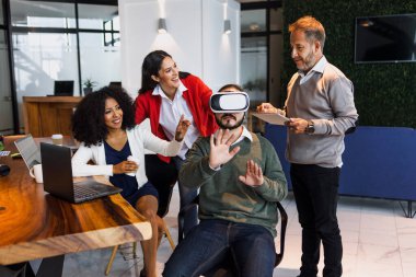 Latin Amerika 'daki ofisinde sanal gerçeklik gözlüğü kullanan bir grup genç Latin iş adamı. İşteki İspanyol insanlar