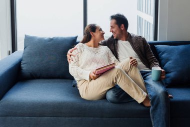 Latin Amerikalı genç çift Meksika 'da kanepede kitap okuyor, aşık İspanyol insanlar.