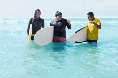 Latin sörfçülerin portresi arkadaşlar Acapulco Mexico sahilinde sörf tahtası olan adamlar. Latin Amerika 'da sörf yapan ve yaz sporlarında eğlenen İspanyol insanlar.