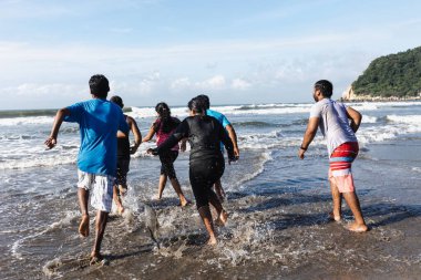 Acapulco Meksika 'nın Pasifik Okyanusu' ndaki plajda atlayıp koşan mutlu Latin arkadaşlar Latin Amerika 'da, İspanyol gençler kadınlar ve erkekler eğleniyor. 