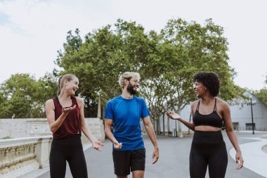 İspanya 'da bir şehir parkında birlikte çalışan bir grup çok ırklı arkadaş. İspanyol ve afro saçlı kadınlar atletik kıyafetler giyip birlikte egzersiz yapıyorlar. 