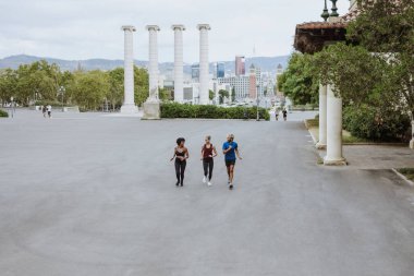 İspanya 'da bir şehir parkında birlikte çalışan bir grup çok ırklı arkadaş. İspanyol ve afro saçlı kadınlar atletik kıyafetler giyip birlikte egzersiz yapıyorlar. 