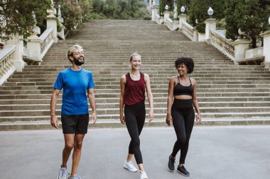 İspanya 'da bir şehir parkında birlikte çalışan bir grup çok ırklı arkadaş. İspanyol ve afro saçlı kadınlar atletik kıyafetler giyip birlikte egzersiz yapıyorlar. 