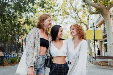 Avrupa şehir caddesinde, İspanyol ve Latin insanların birlikte yürüdüğü bir grup çok ırklı kadın eğleniyor. 