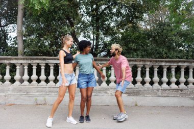 Bir grup çok ırklı arkadaş yaz mevsiminde Avrupa 'da şehir sokaklarında eğleniyor. 