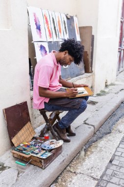 Latin Amerika 'da Afrikalı Amerikalı ressam ya da rastalı ressam ve afro saç boyası, Afro-Karayipli bir adamın sokak resmi.