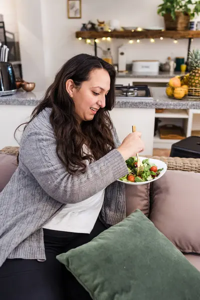 Latin Amerika 'da evde sebze salatası yiyen şişman Latin bir kadın. Meksikalı bir kadın. Yanında bir kase sağlıklı yiyecek taşıyor.