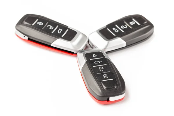 stock image Car keys lie in different poses on a white background. Black and red car alarm key fobs are located on a white background.