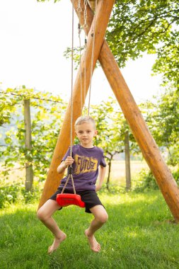 Yedi yaşında bir çocuk bahçede salıncakta sallanıyor.