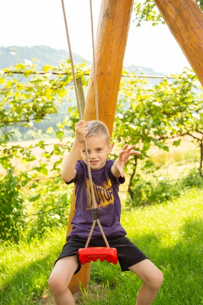Boy Seven Years Old Rides Swing Garden — Stock Photo, Image