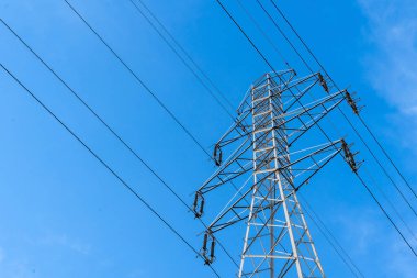Şehre ve köye elektrik sağlamak için elektrik istasyonu. Yüksek voltajlı elektrik kulesi. Yakın plan. Mavi gökyüzüne karşı güç hattı. 
