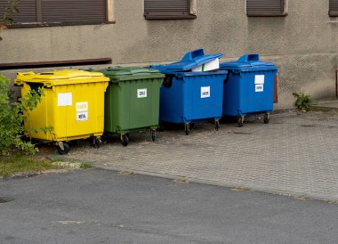 Siyah, mavi, sarı, yeşil çöp geri dönüşüm kutuları. Atıkları ayır, çevre kavramını koru. Atıkları ayır, çöpleri ayır. Kağıt, cam, plastik renkli çöp tenekeleri.