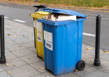 Siyah, mavi, sarı, yeşil çöp geri dönüşüm kutuları. Atıkları ayır, çevre kavramını koru. Atıkları ayır, çöpleri ayır. Kağıt, cam, plastik renkli çöp tenekeleri.